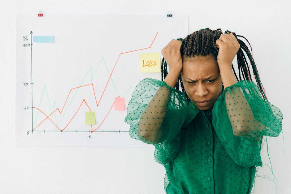 Frustrated businesswoman in green blouse analyzing a graph showing financial loss